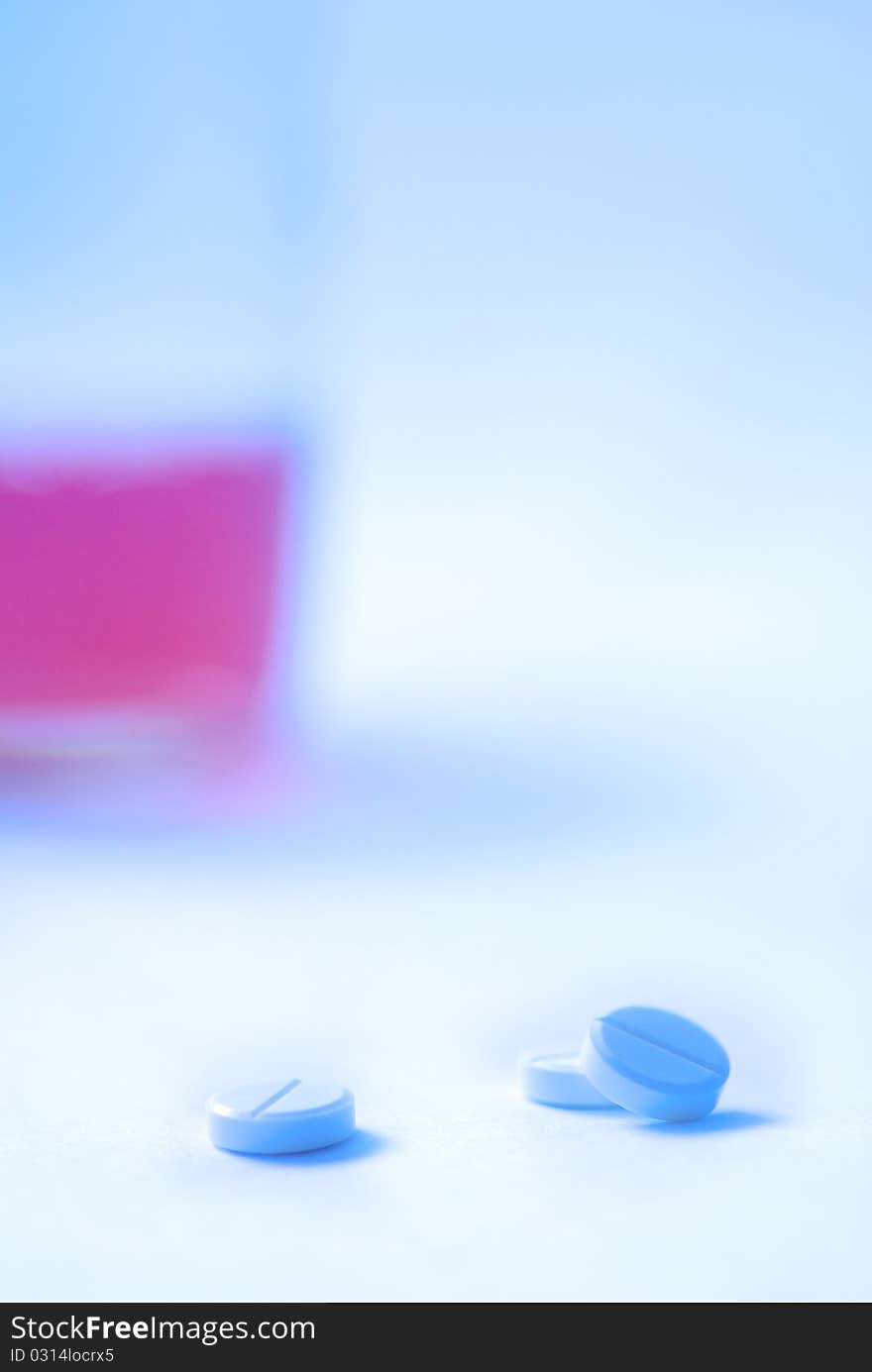 Three tablets against the glass with liquid, white background, creative