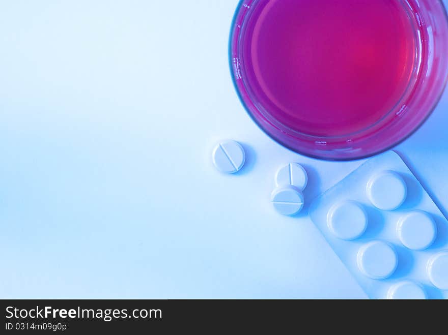 Tablets, drugs and a glass of liquid, close-up, top view