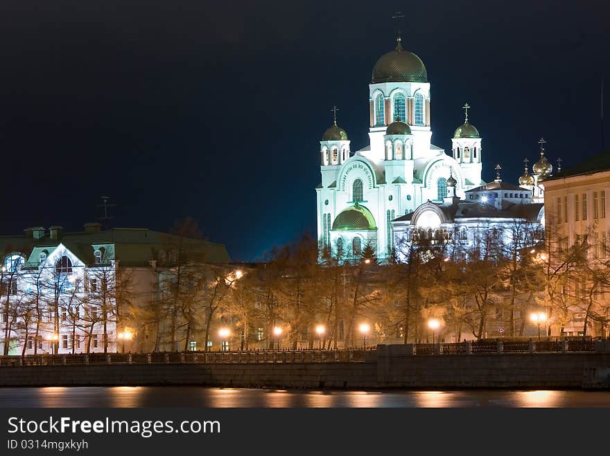 The night brightly shined city landscape on river bank. The night brightly shined city landscape on river bank