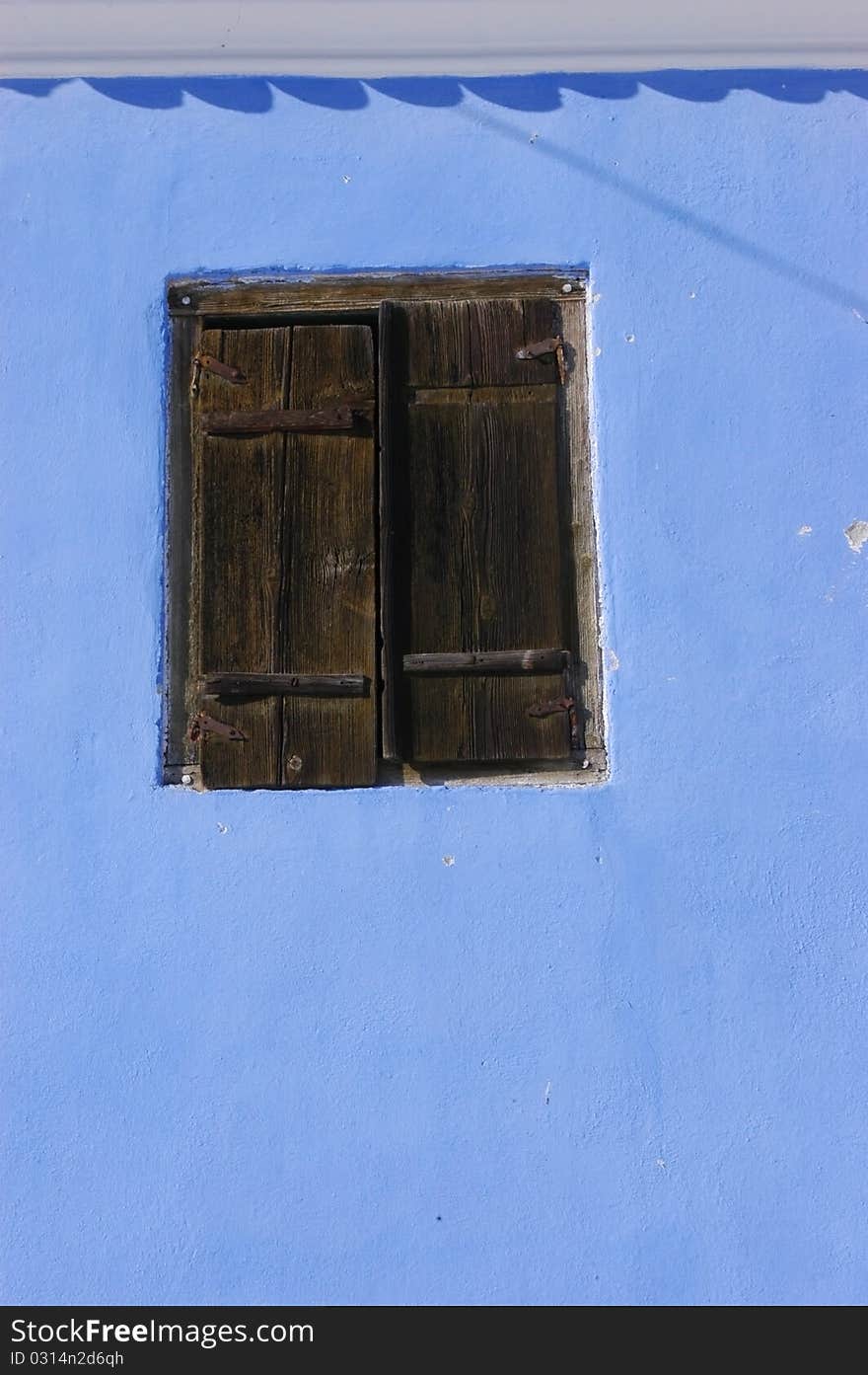 Blue wall with a wooden window