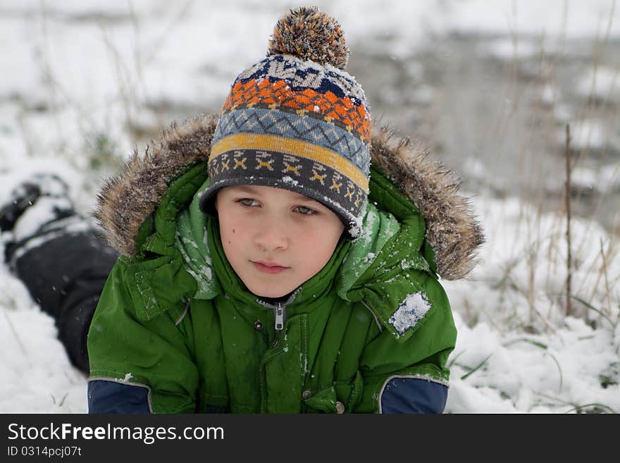 The boy lies on snow