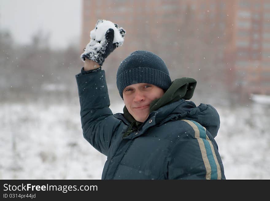 The man plays snowballs, in the winter in the street