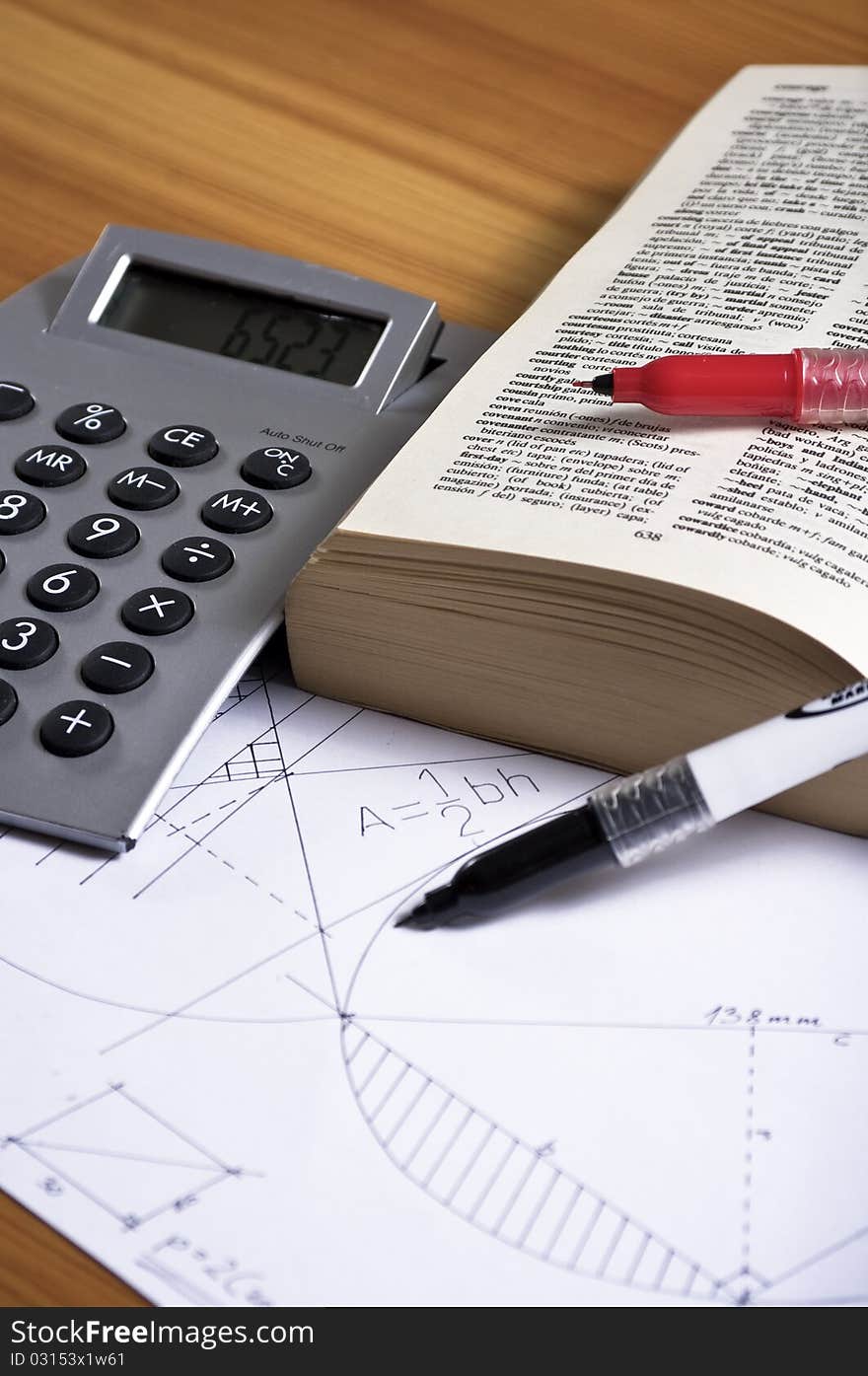 Geometry paper with book, markers and calculator on wooden desk. Geometry paper with book, markers and calculator on wooden desk.