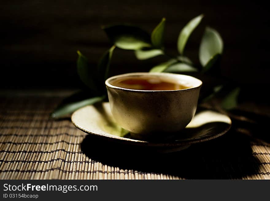 Cup of tea and twig with dark background