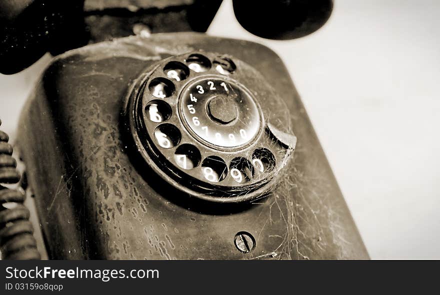 Black disc phone on white wall, vintage object. Black disc phone on white wall, vintage object