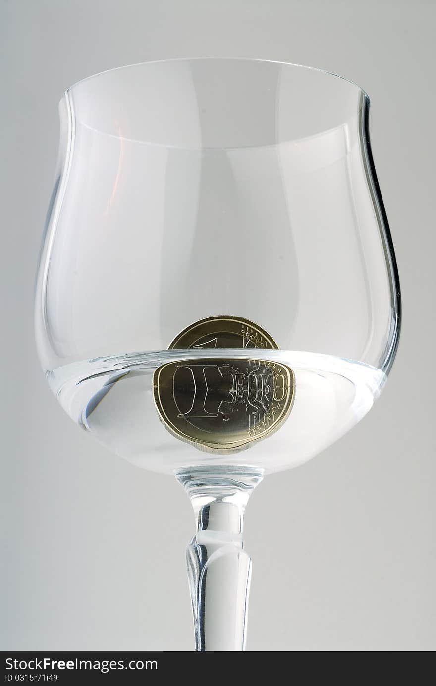 A one Euro coin in a crystal goblet with water. A one Euro coin in a crystal goblet with water