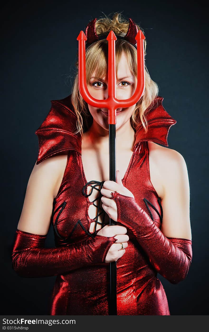 Red devil woman with trident on black background