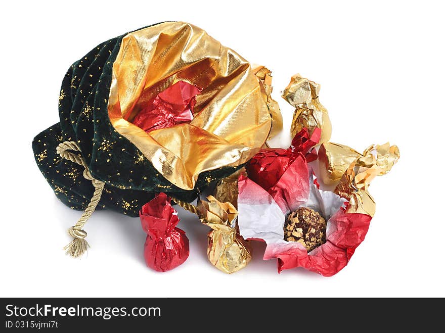 Christmas sack with golden ribbon full of chocolate candies on white background