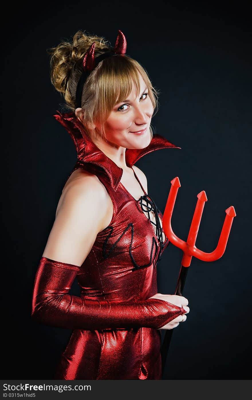 Red devil woman with trident on black background