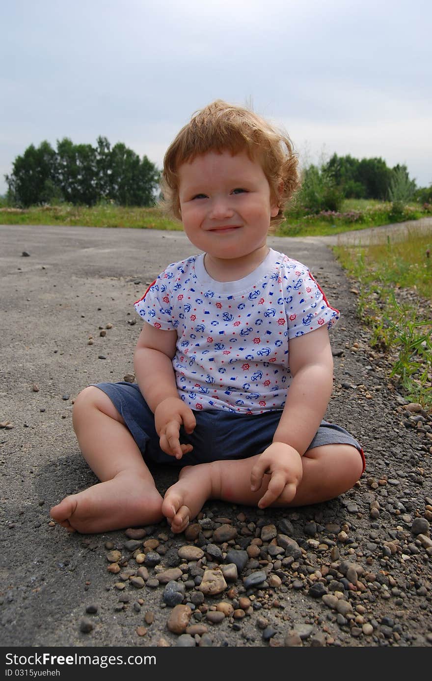 A Child Sitting On The Ground