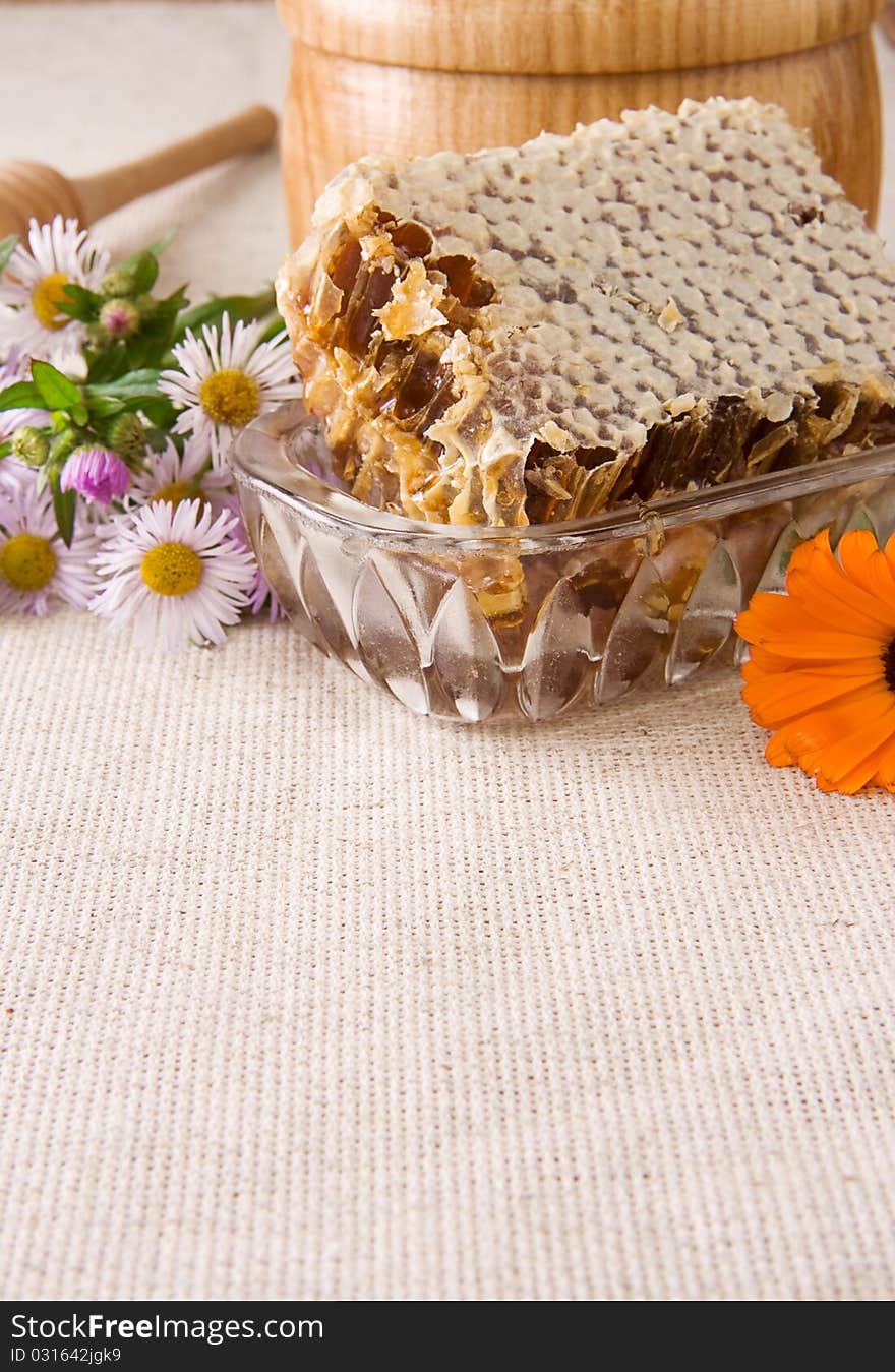 Honey, Honeycomb In Pot, Stick And Flowers On Sack