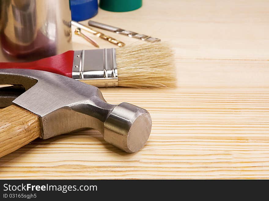 Hammer, paintbrush and other instruments on wood