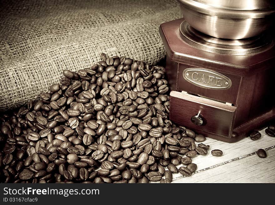 Coffee beans and grinder on sacking on vintage. Coffee beans and grinder on sacking on vintage