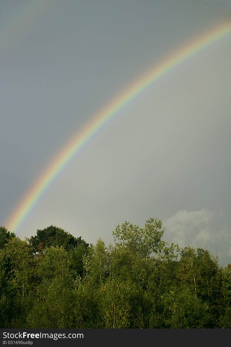 A half rainbow across a cloudy sky. A half rainbow across a cloudy sky