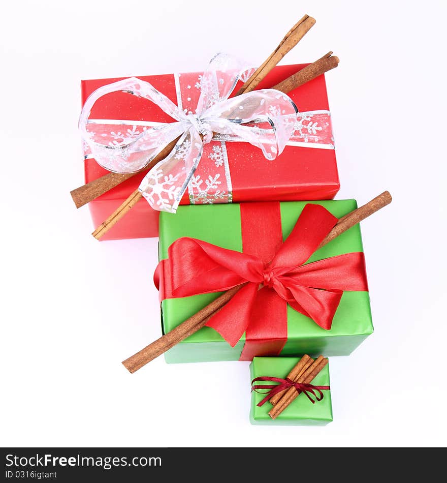 Gift with bows decorated with cinnamon sticks on white background. Gift with bows decorated with cinnamon sticks on white background