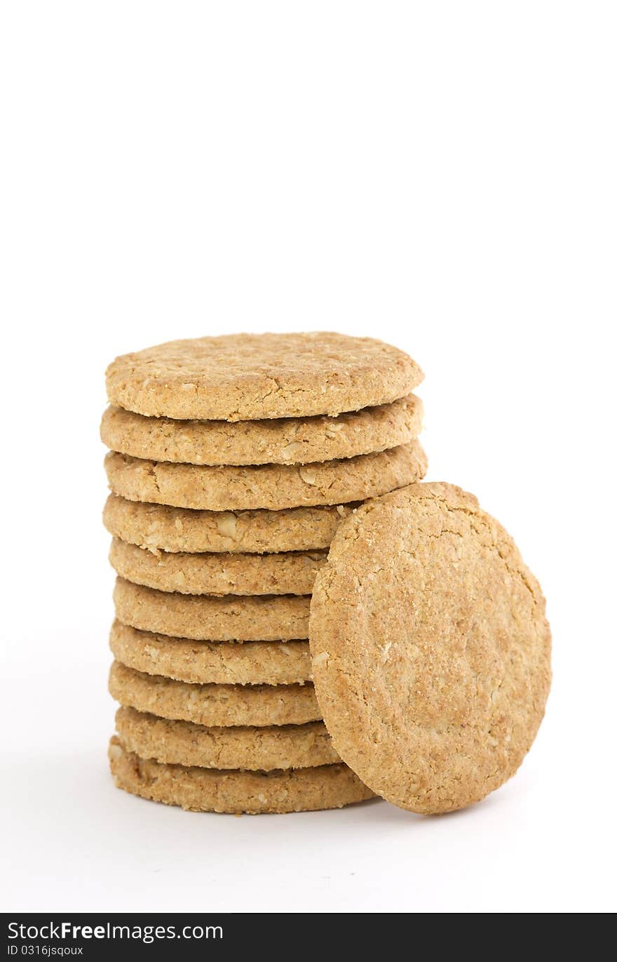 Pile of ten oaty cookies with one leaning against isolated on white. Pile of ten oaty cookies with one leaning against isolated on white