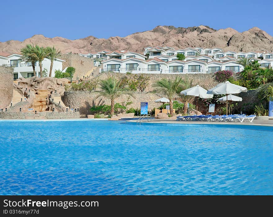 White hotel with swimmingpool and rock behind it. White hotel with swimmingpool and rock behind it