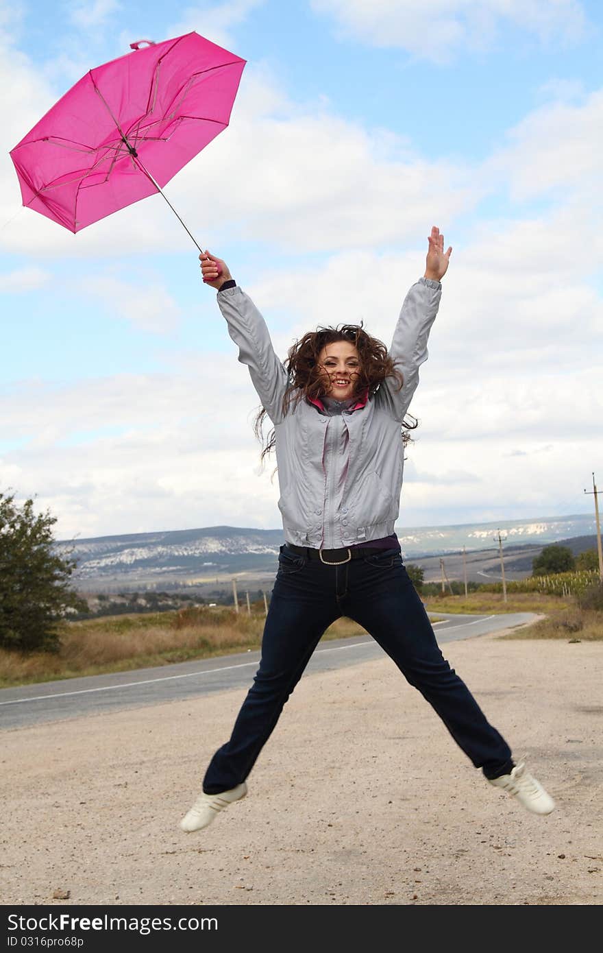 Joyful young lady jumping with bright pink umbrella. Joyful young lady jumping with bright pink umbrella