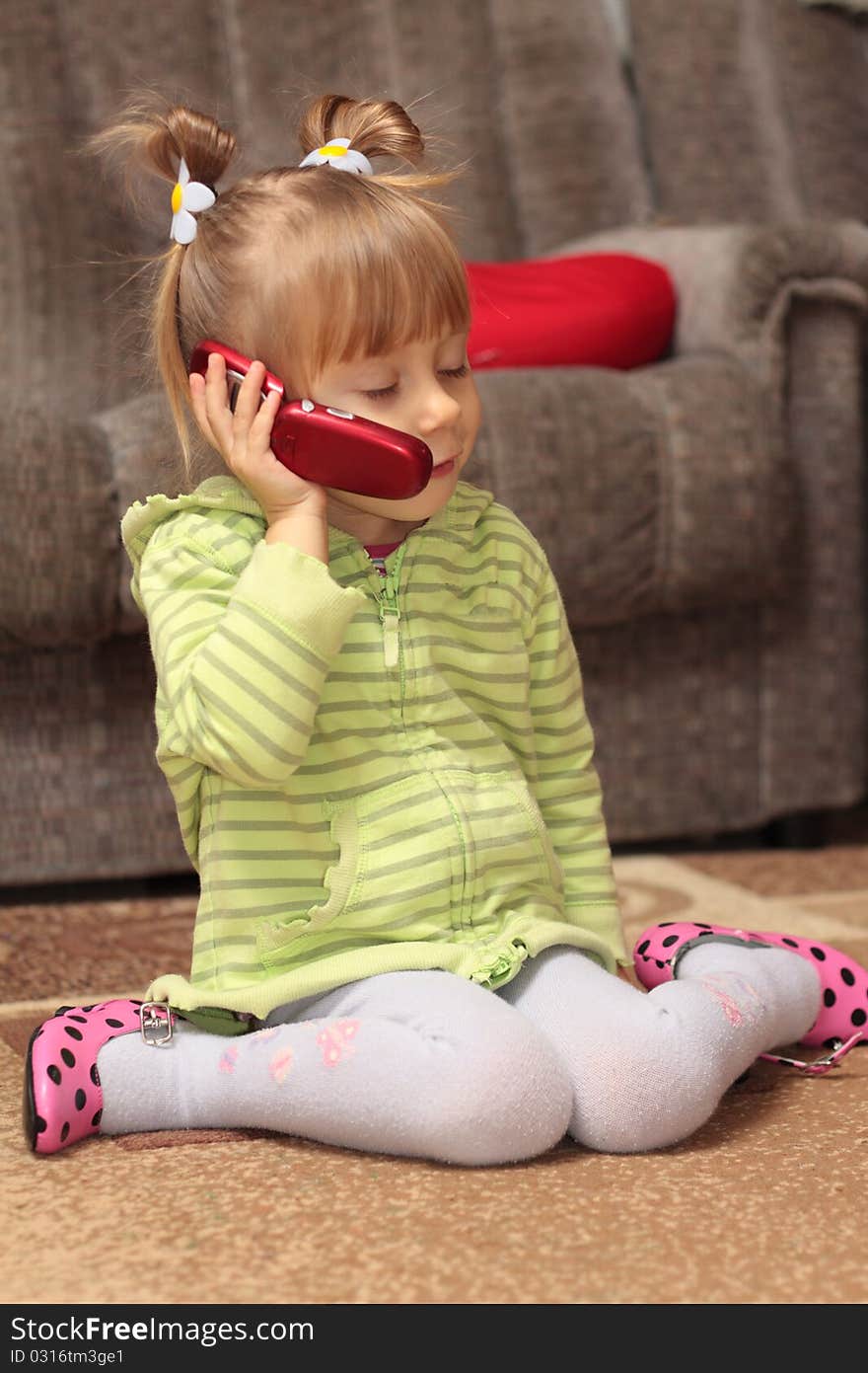 Charming little girl talking on the phone