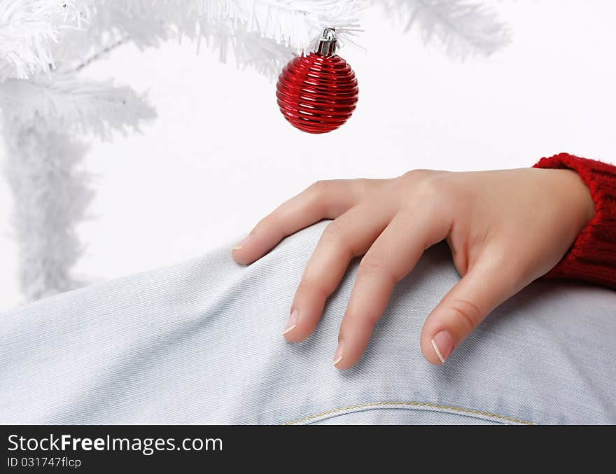 Woman hand with a white christmas tree in the background