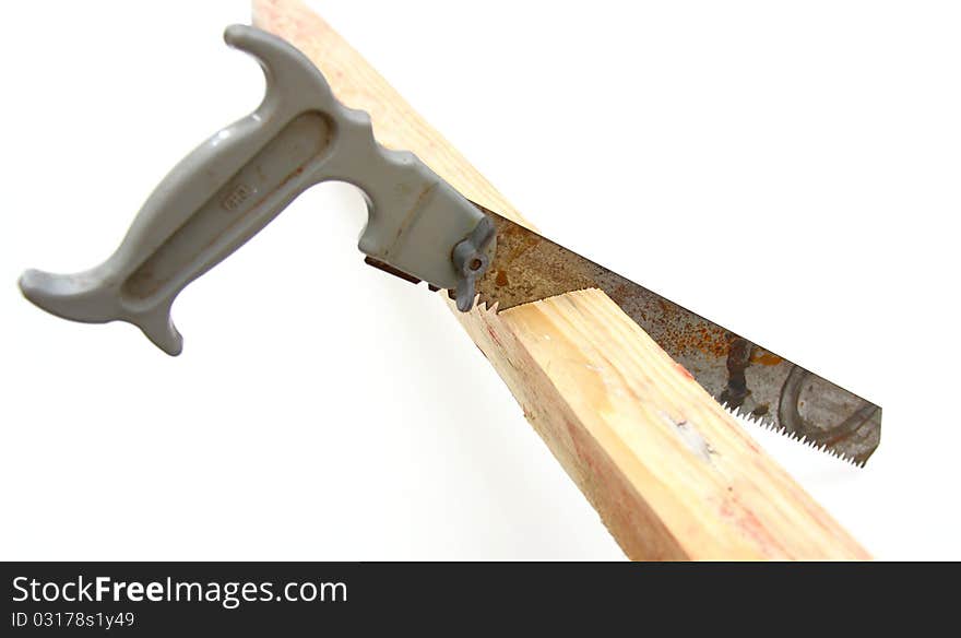 Hacksaw in sawed yellow wooden board on white background