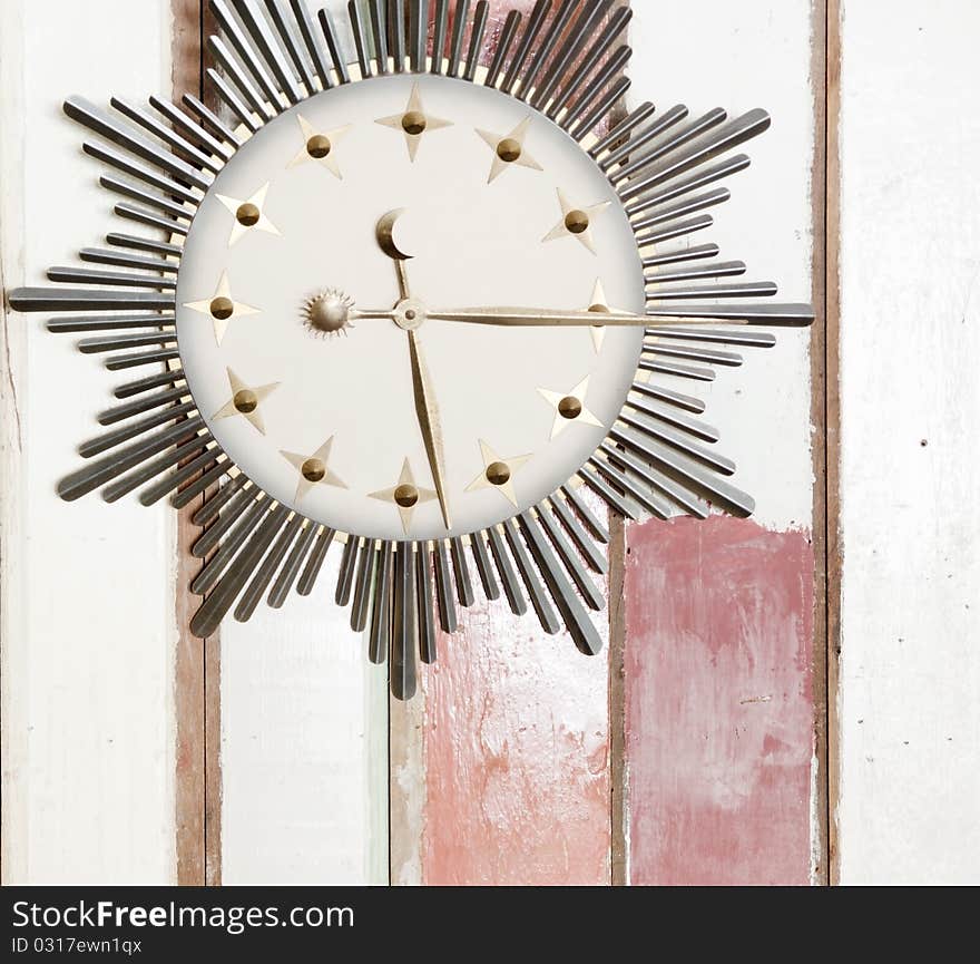 Retro clock with sign of sun moon and stars on wooden wall