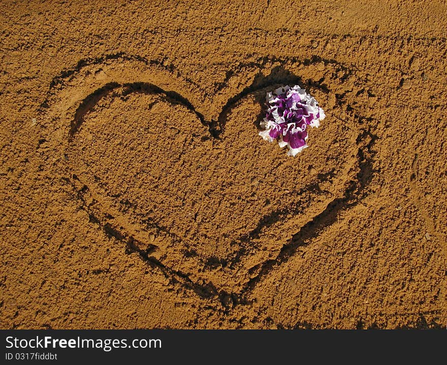 Drawing Heart on sand and purple flower