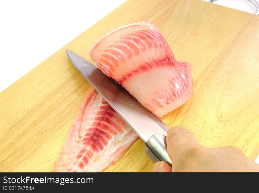 Red tilapia on wood chopping block .