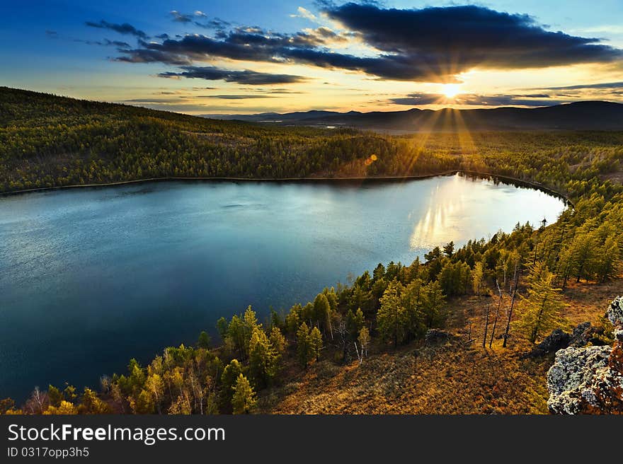 Sunset under the lake and forest