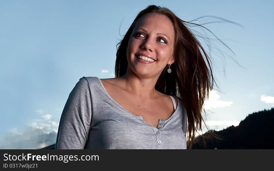 Young beautiful woman with blue sky in the background. Young beautiful woman with blue sky in the background