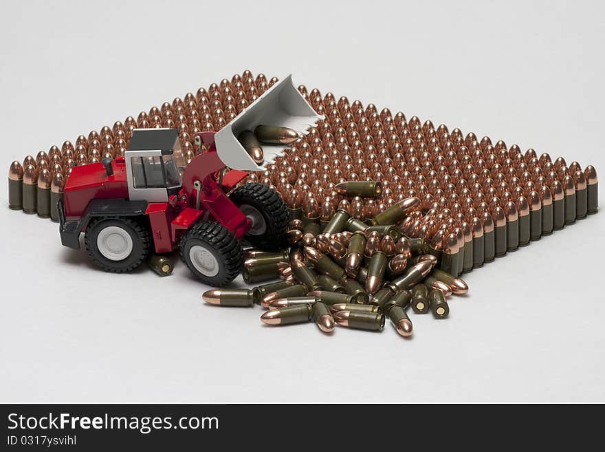 Pattern of pistol cartridges with toy bulldozer on light background.