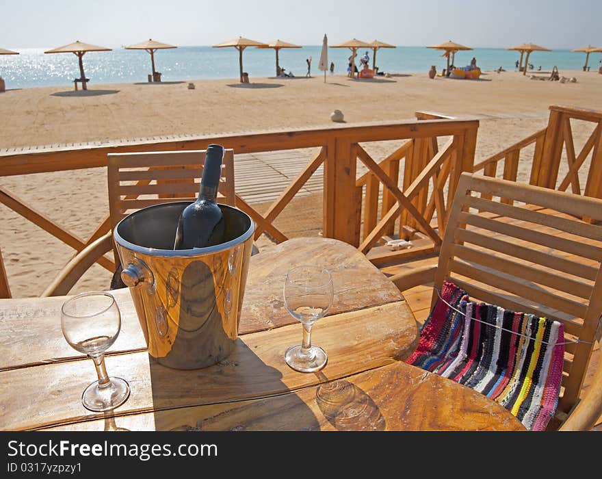 Wine Bottle And Glasses On A Table At A Beach