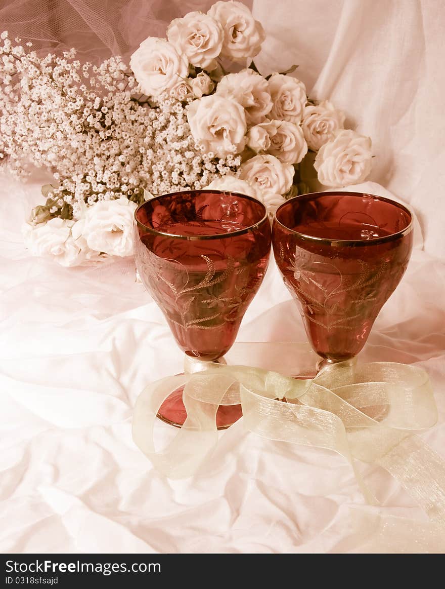 Toned photograph.A bouquet of roses and two glasses. Toned photograph.A bouquet of roses and two glasses