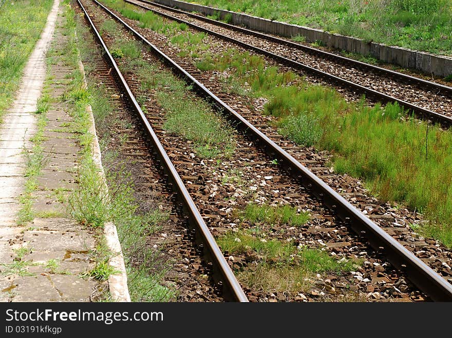 Old railroad tracks going through green grass. Old railroad tracks going through green grass