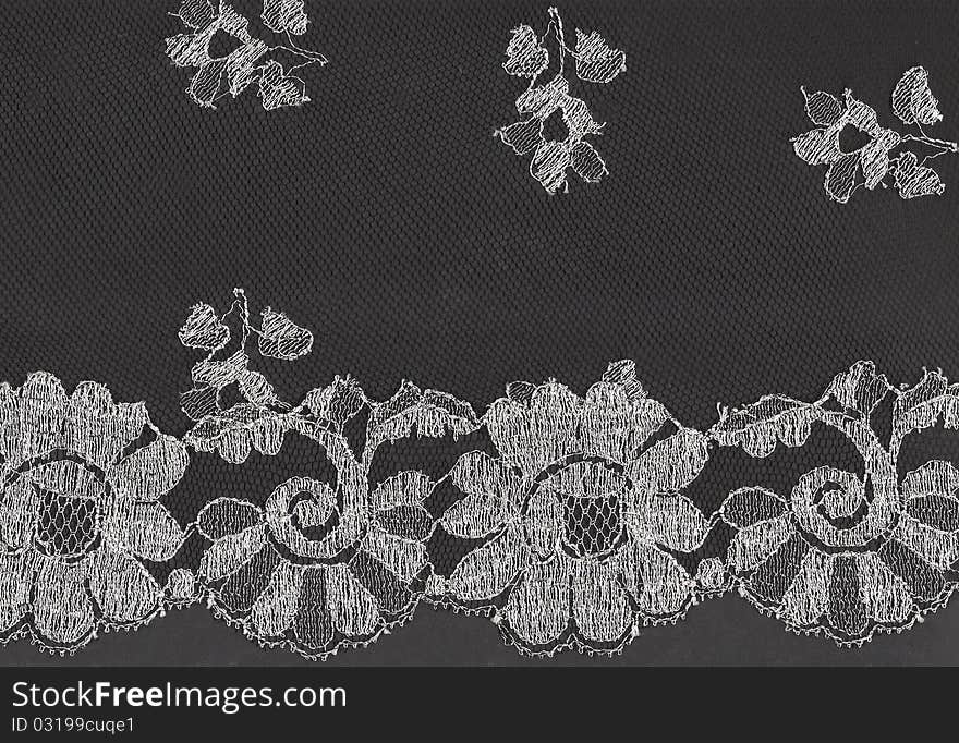 Pattern of black lace fabric with floral motif against black background. Pattern of black lace fabric with floral motif against black background