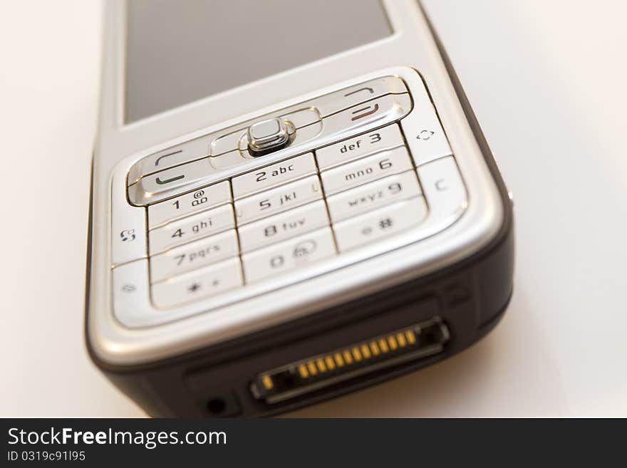 Close-up of silver mobile phone isolated on white background.