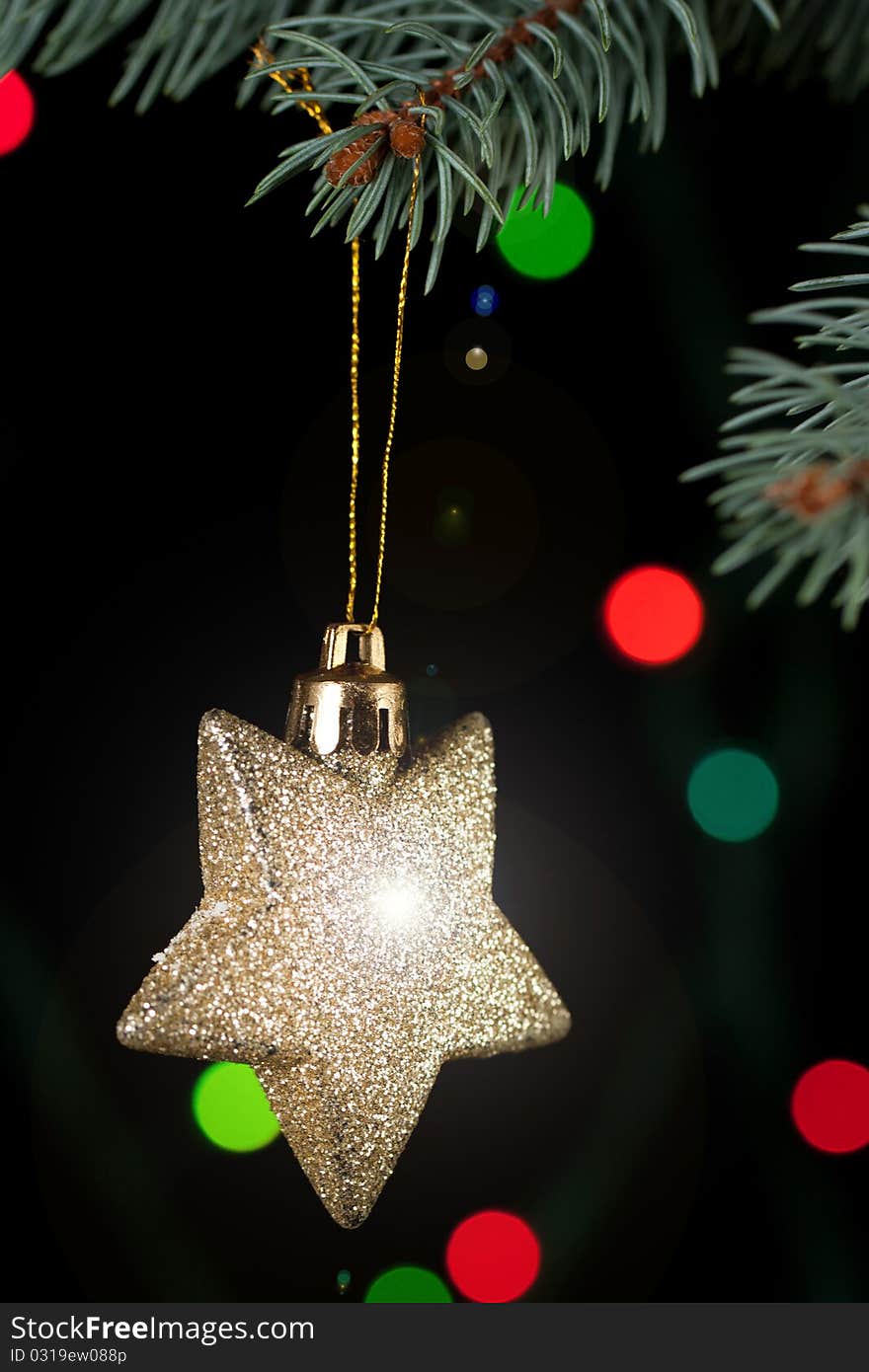 Golden christmas star with a christmas tree on the black background