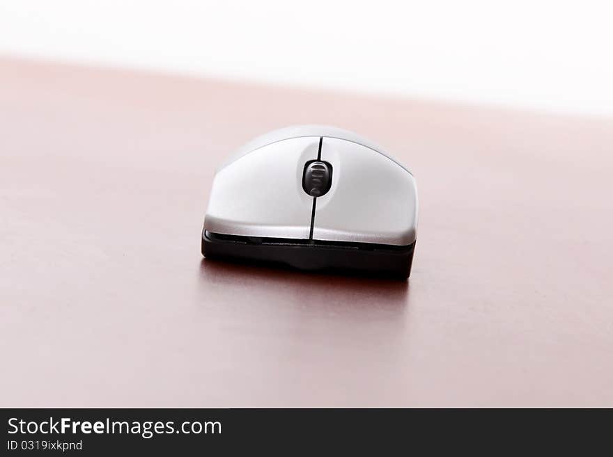 Computer mouse on wooden table over white background