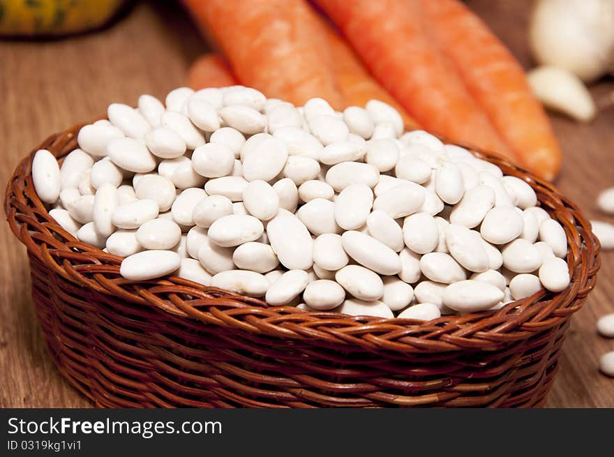 Haricot bean and fresh vegetables on an old wooden table