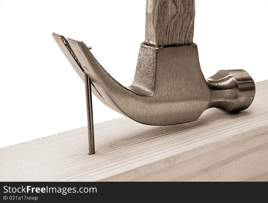 Hammer and nail isolated on wood brick on sepia