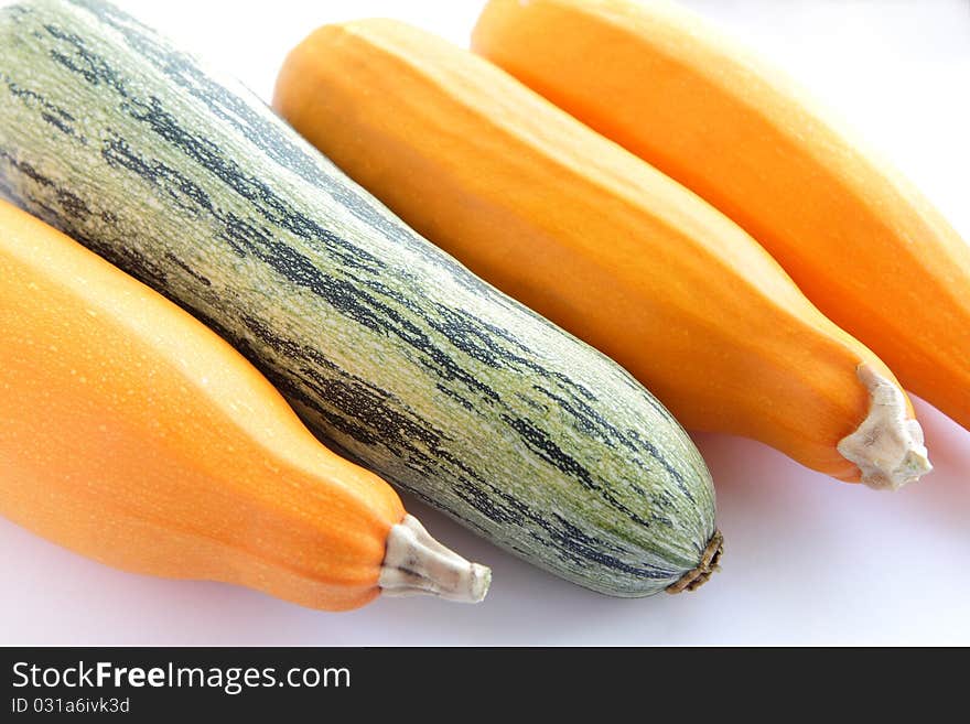 One green and three yellow fresh zucchini (courgettes) isolated on white background. One green and three yellow fresh zucchini (courgettes) isolated on white background