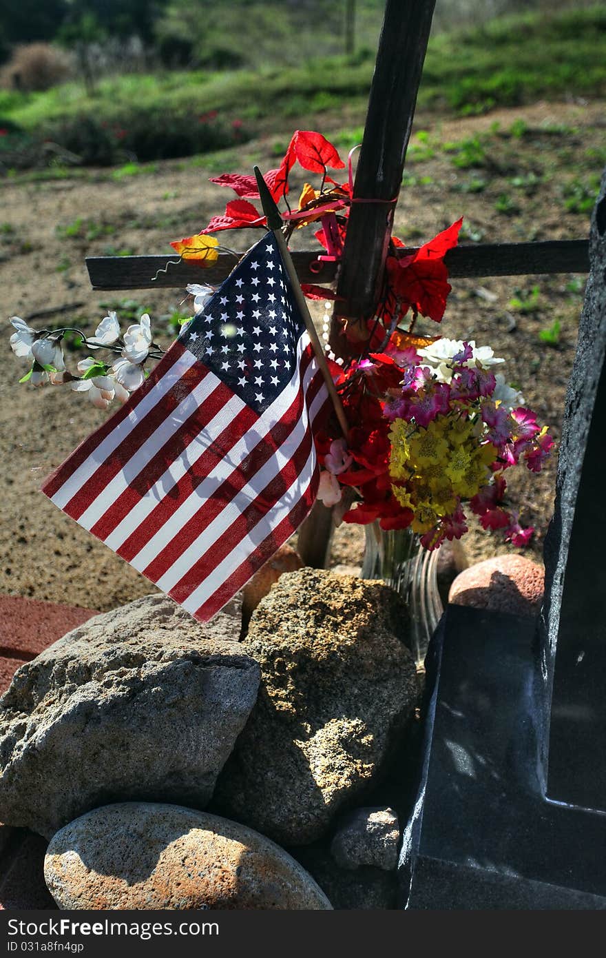 Very old country gravesite with a cross and American flag