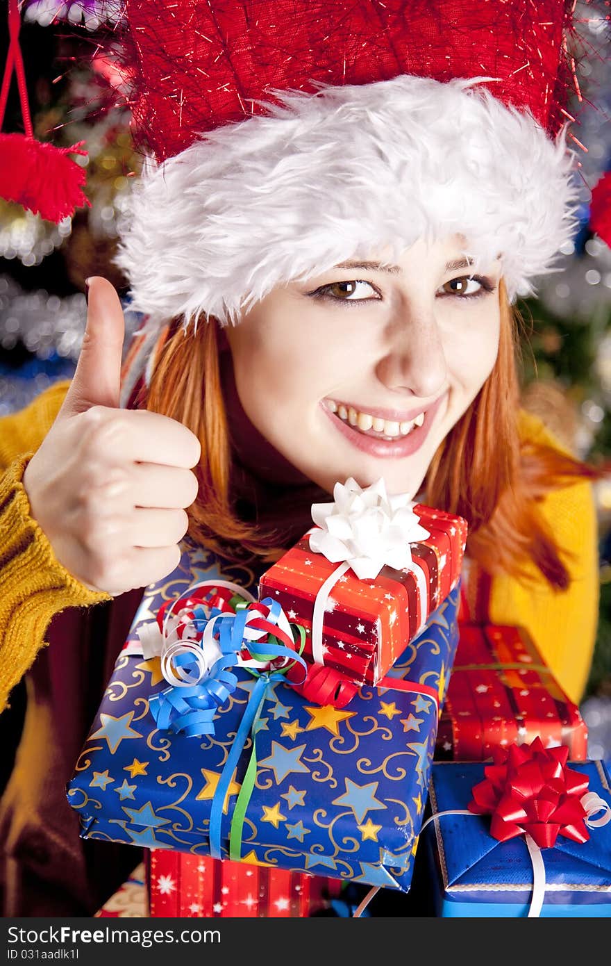 Funny girl in christmas cap with gift boxes