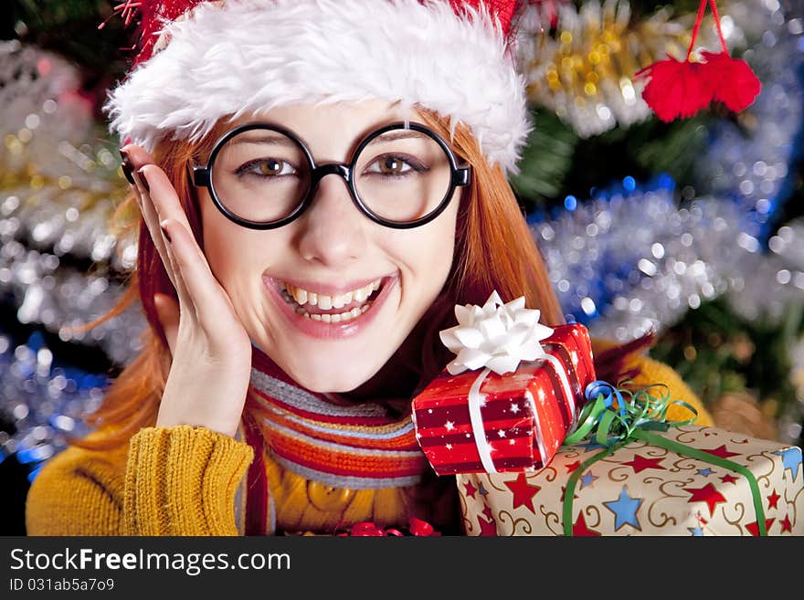 Funny girl in christmas cap with gift boxes