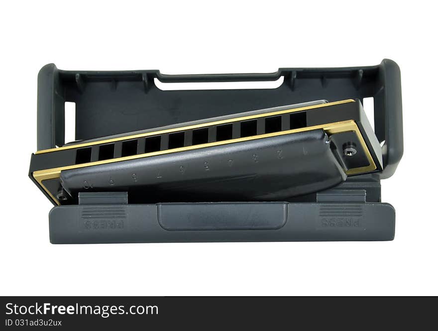 A black and brass blues harp in it's black plastic case. Isolated on a white background. The Blues harp is used in Blues music and sometimes in Country music. A black and brass blues harp in it's black plastic case. Isolated on a white background. The Blues harp is used in Blues music and sometimes in Country music.