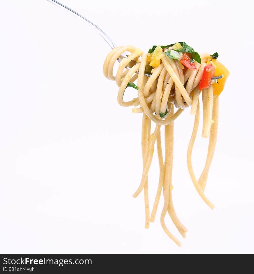 Spaghetti with vegetables on a fork on white background. Spaghetti with vegetables on a fork on white background