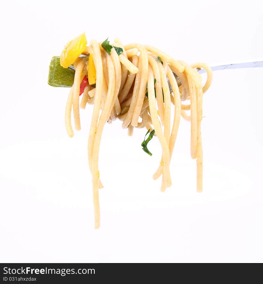 Spaghetti with vegetables on a fork on white background