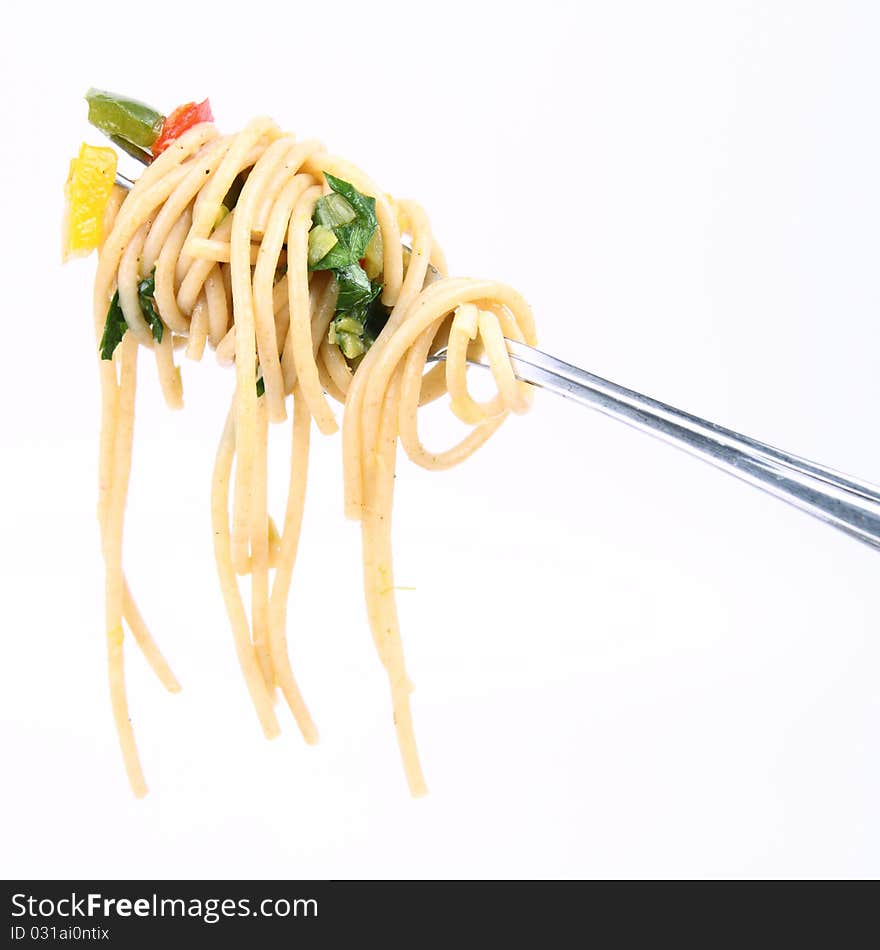 Spaghetti with vegetables on a fork on white background