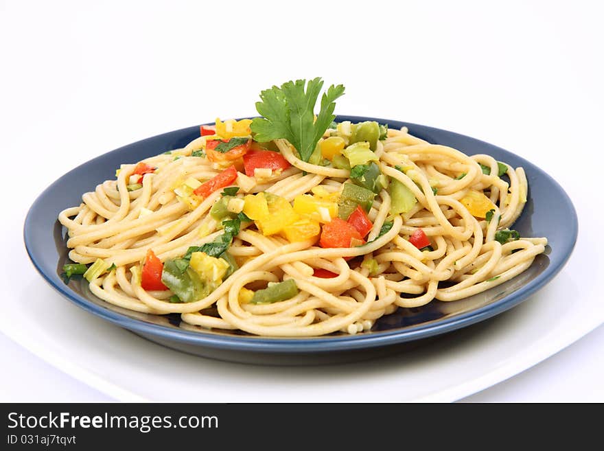 Spaghetti with vegetables on a plate on white background