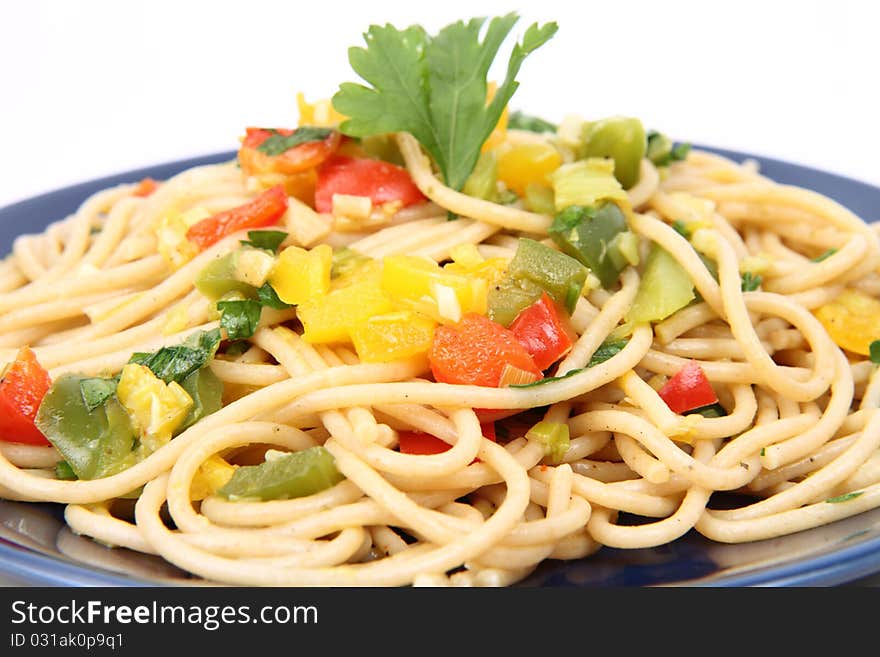 Spaghetti with vegetables on a plate on white background